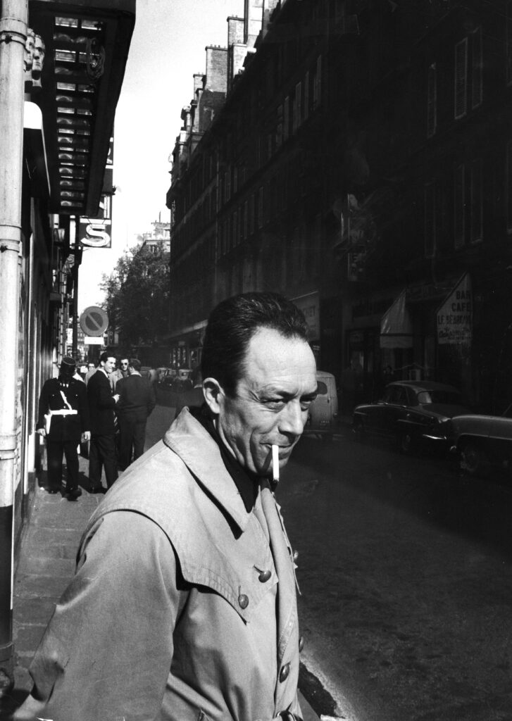 Albert Camus smoked a cigarette outside Theatre des Mathurins, where the rehearsals of his play Caligula were taking place, 1957.