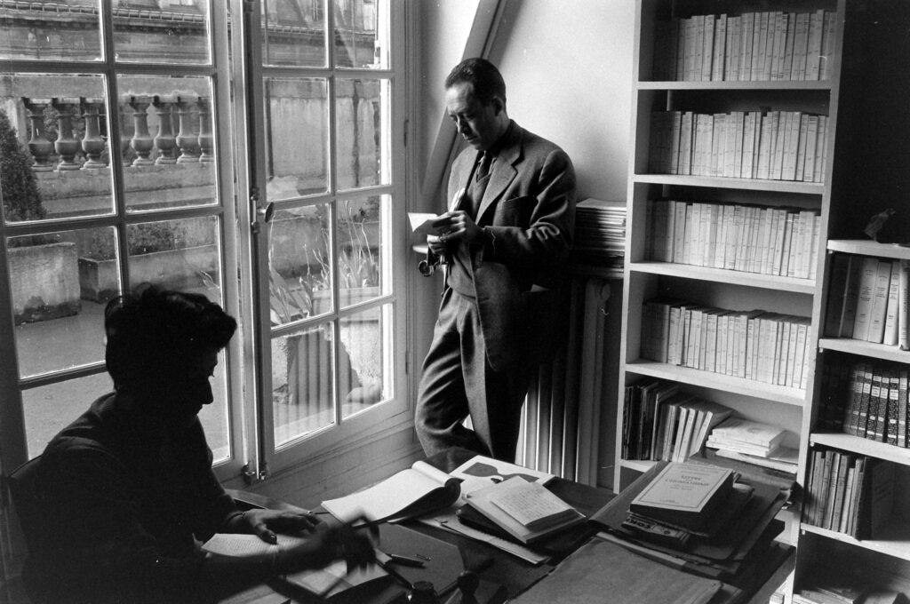 Albert Camus leaned against a radiator in his office, Paris, 1957.